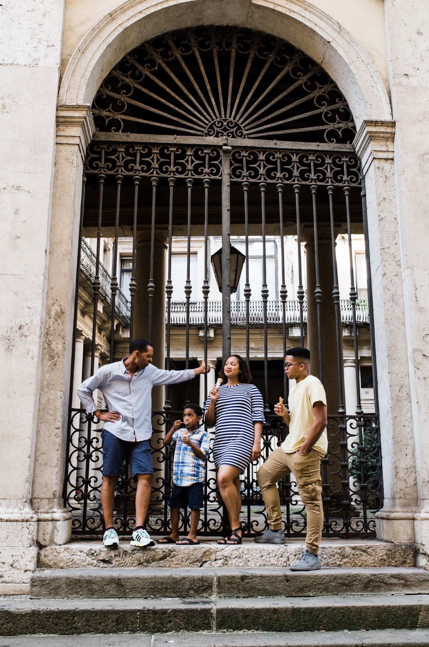 Christy's family sharing ice cream beneath an ornate courtyard gate.